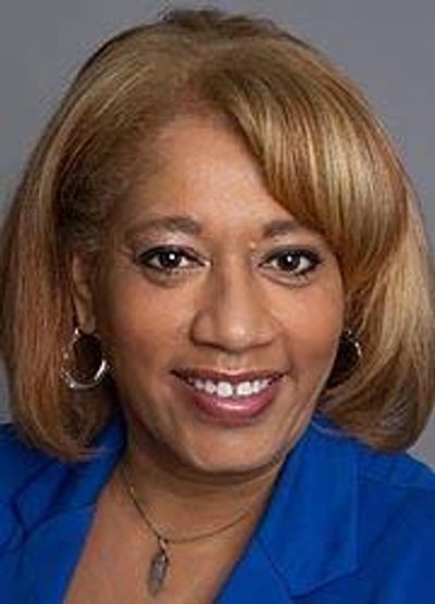 Portrait of a smiling woman with light brown hair and blue blazer.
