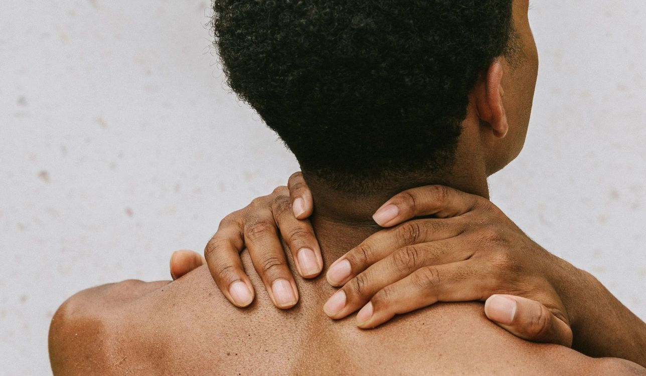 Person holding their neck in discomfort.