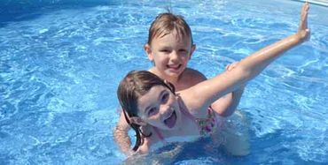 2 kids playing on a pool