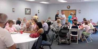 A group eating at tables in the event space at the resort
