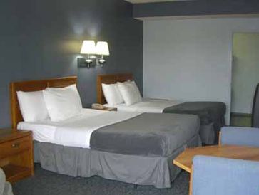 Guest room at the resort showing 2 beds with white pillows and grey comforter and a desk