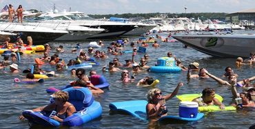 Several boats and people on rafts on the lake