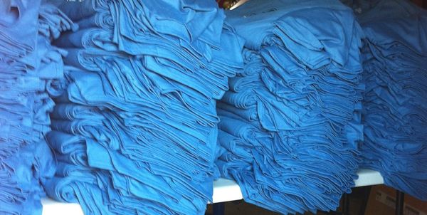 Piles of shirts in our shop ready to be printed