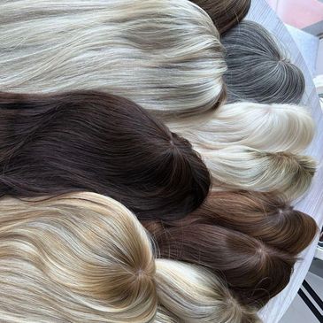 Various hairpieces in different shades arranged on a surface.