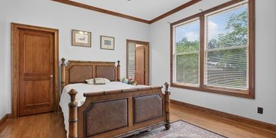 Cozy bedroom with wooden furniture and large window.
