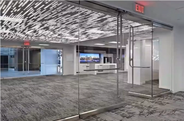 Modern office space with glass walls and a futuristic ceiling design.