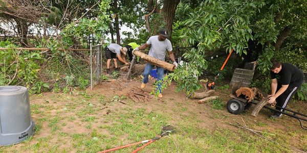Crew clearing cut tree limbs during a residential tree service project in Yukon, Oklahoma.