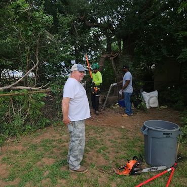 Johnson Tree Surgery crew clearing cut branches and tree debris from a residential yard in Yukon, Ok