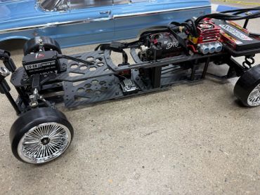Chassis of a remote control car with detailed wheels and engine.
