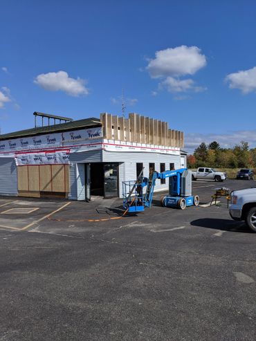 Building under construction with a blue Genie lift in the parking lot.