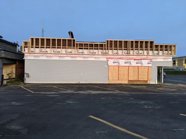 Building under construction with exposed framing and plywood.