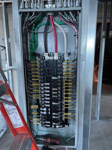 Well-organized electrical panel with labeled breakers and neatly arranged wires.