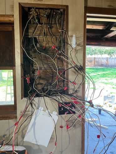 Old electrical wiring with damaged insulation and labels.