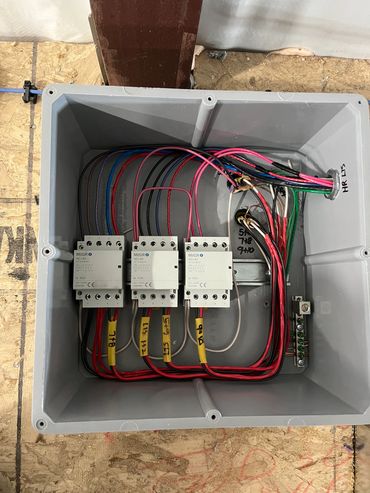 Electrical junction box with labeled wires and contactors.