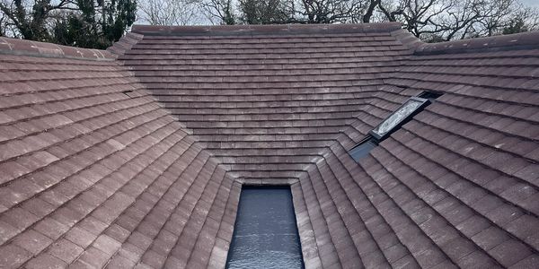 A close-up view of a rooftop with tiles and a small window.