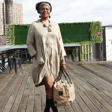 A lady wearing long dress, smiling at the camera