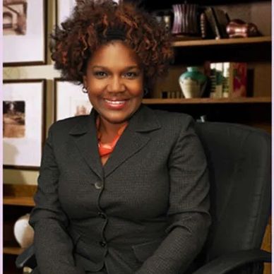 A lady wearing black dress smiling at the camera