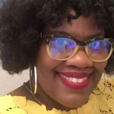 A girl wearing spectacles smiling at the camera