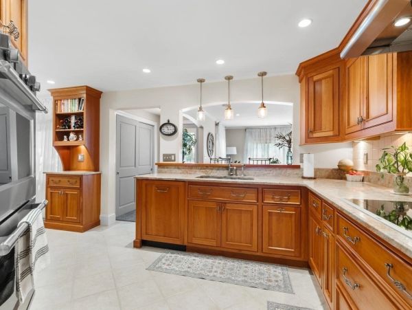 Spacious kitchen with wooden cabinets and modern lighting.