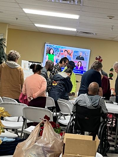 Community gathering watching TV news.
