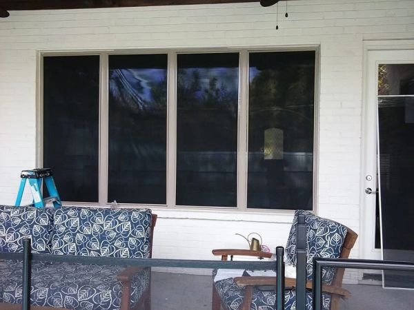 Outdoor patio with leaf-patterned cushions and large windows.