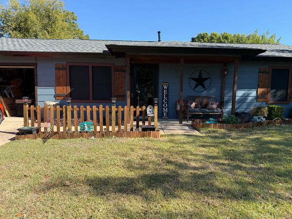 Blue house with wooden shutters and a welcoming front porch.