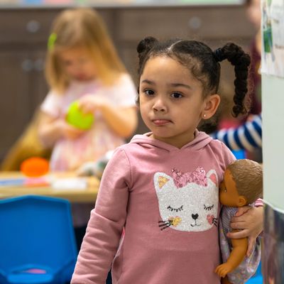 african american girl holds doll before washing hands for healthy lunch and naptime