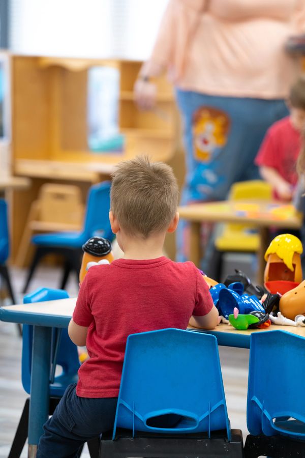 Boy plays with Mr. Potato head at Wee Care