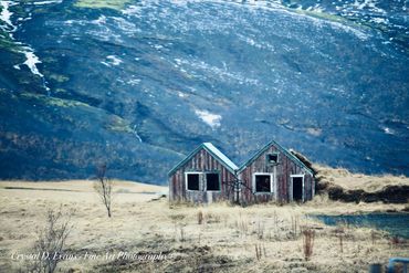 'Fleetingly paired' is a colour photograph of two abandoned shelters against a basalt background