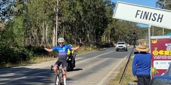 Cyclist celebrating at finish line during race.