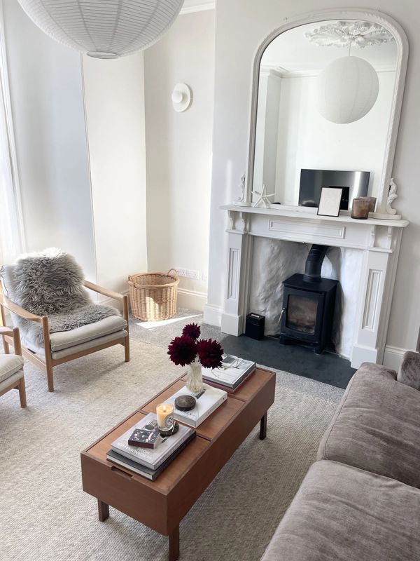 Cozy living room with neutral tones, wooden furniture, and a fireplace.