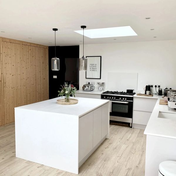 Modern minimalist kitchen with white cabinetry and wood accents.
