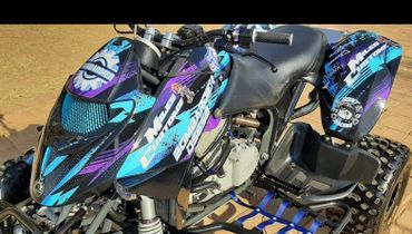 Close-up of a colorful all-terrain vehicle with bold decals and rugged tires.