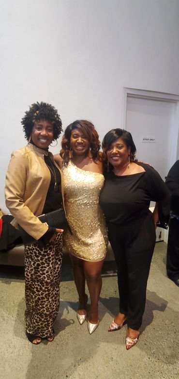 Photo of three women with white wall