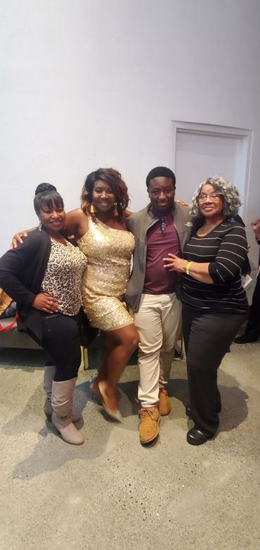 Group photo of men and women against a white wall