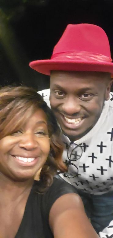 Couple posing for a photo with a red hat