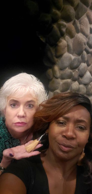 Pebbled wall with two women in the front