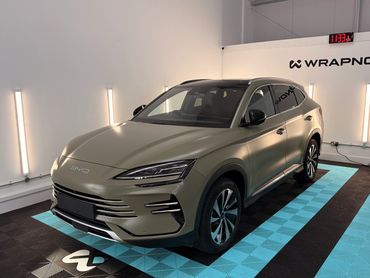 Matte olive green SUV parked in a well-lit garage with WRAPNOVA branding.