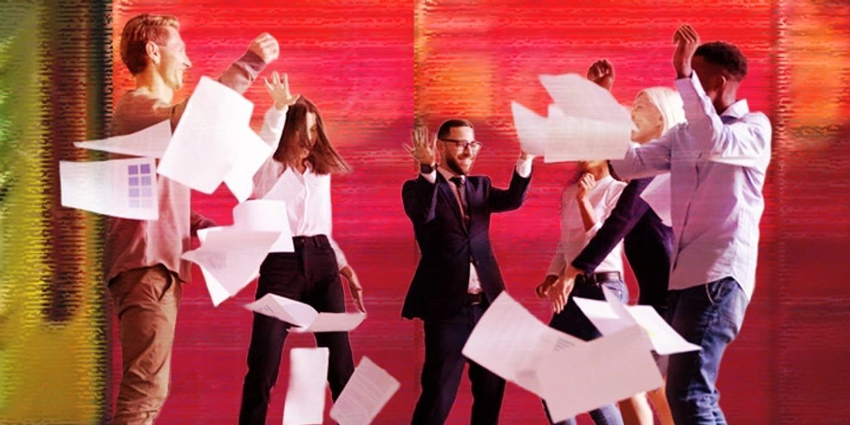 Group of professionals joyfully throwing papers in the air.