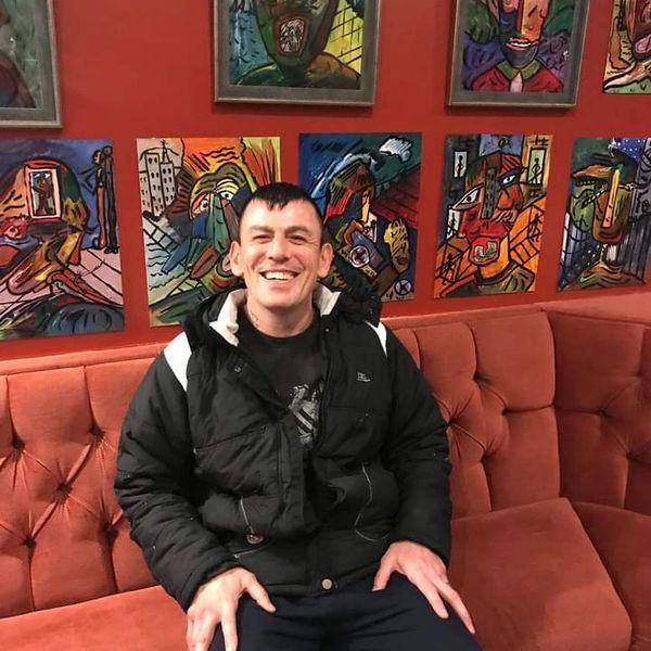 Robert Haworth - The Butterfly Man sitting in front of his paintings