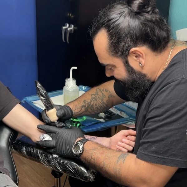 Hector Salazar, Yuma's finest tattoo artist is applying a tattoo on a customer.