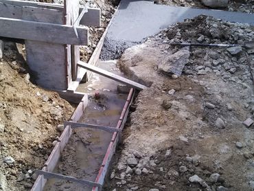 Construction site with concrete foundation and wooden formwork.