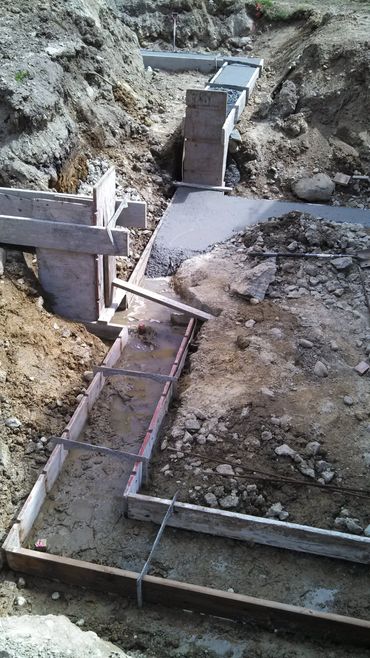 Construction site with concrete foundation and wooden formwork.