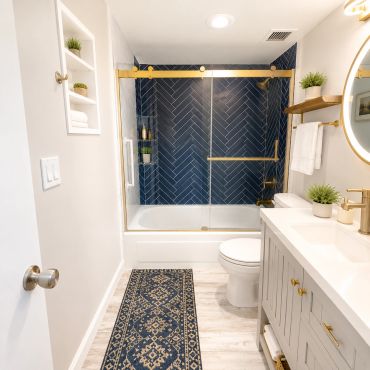 Modern bathroom with gold accents and blue tile shower.
