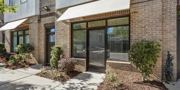 Modern brick building entrance with glass door and awning.