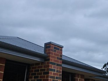 Brick house exterior with cloudy sky.
