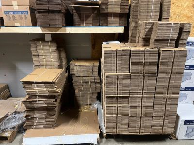 Stacks of flattened cardboard boxes stored on pallets.