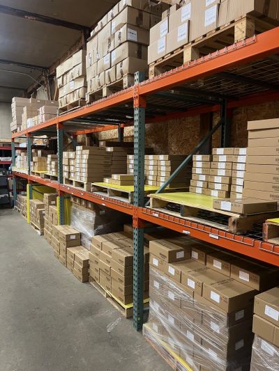 Warehouse shelves filled with stacked cardboard boxes.