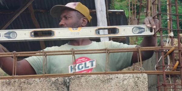 Man using a spirit level on a construction site.