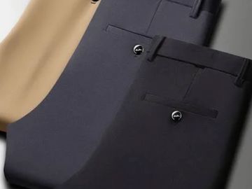 Three pairs of neatly folded dress pants in beige, navy blue, and black.